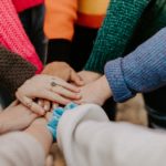 hands and forearms joined together at the centre of a circle