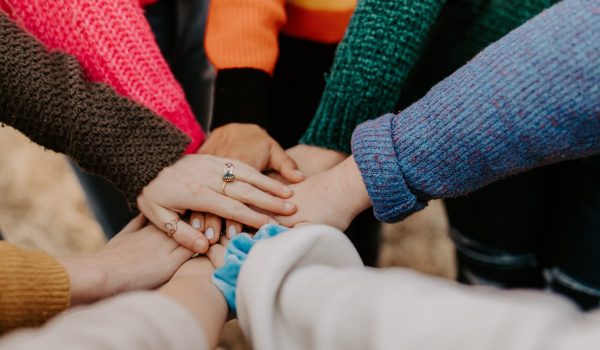 hands and forearms joined together at the centre of a circle